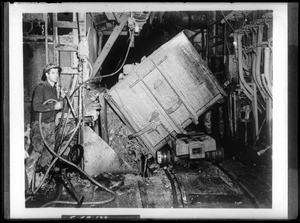 Man dumping mining tailings in a tunnel during the construction of the Colorado River Aqueduct, ca.1930