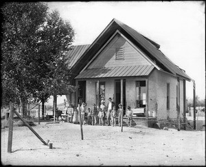 Group of students with their teacher in front of the Indian school at Martinez, ca.1900