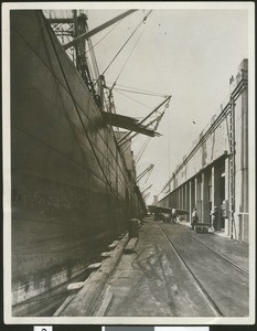 Ship unloading lumber at a wharf, ca.1920