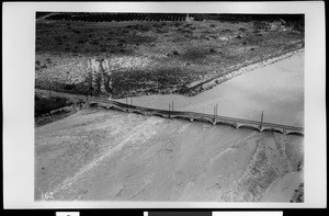 Aerial view of flood in Azusa, showing damage of San Gabriel Railroad Bridge over a river, California, 1938