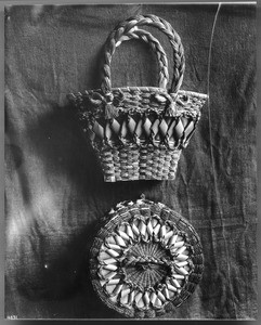 Two Indian baskets displayed against a cloth backdrop, ca.1900