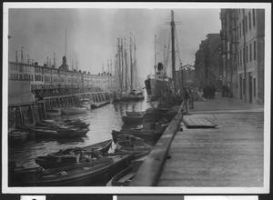 Steamship, sailing ships, and several small boats along a wharf, ca.1920