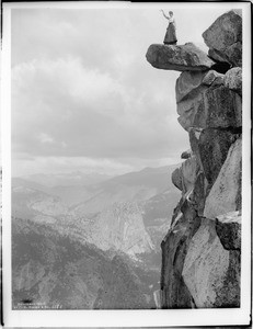 Woman (Miss Loomis?) standing on the precarious Glacier Point in Yosemite National Park, 1900-1902