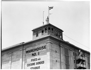 Exterior view of a warehouse with the Marine Exchange building on the roof