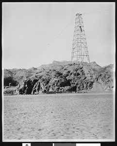 Single transmission tower, showing employees working on it, ca.1950