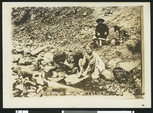 Several people around a creek bed