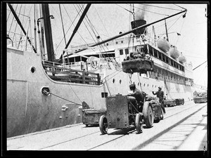 Tractors bringing loads of bananas to waiting ship at the Los Angeles Harbor docks