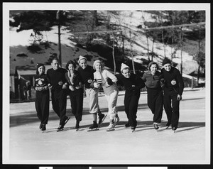 Figure skaters forming a row on an ice rink at Big Pines mountain camp, ca.1930