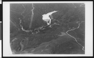 Aerial view of an unidentified reservoir showing the front side of a dam, ca.1920