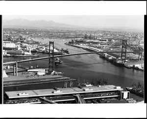 Birdseye view of the main channel of the Port if Los Angeles, looking north over the Vincent Thomas Bridge in San Pedro, ca.1970