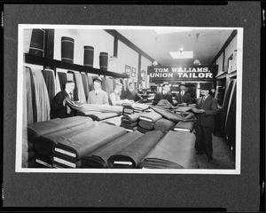 Interior view of the Tom Williams Tailor Shop, showing men examining fabrics, 1880-1920