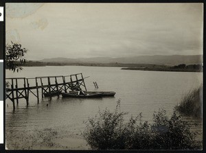 Man in a boat near a dock on Laguna Granda or College Lake in Watsonville, ca.1900