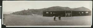 Four men standing in front of the California National Guard Air Unit hangars, in April 1925