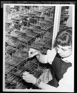 Technician testing a connection in the internal wiring of a Burroughs 205 Electronic Digital Computer, 1950-1960