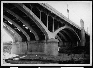 Concrete viaduct over a river (possibly the Los Angeles River), shown from below the viaduct