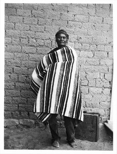 Navajo Indian chieftain standing with a case at his feet, ca.1900