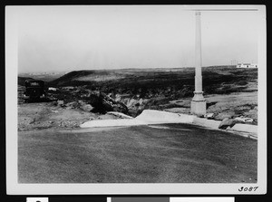 Termination of an unidentified paved street, showing an automobile