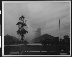 Exterior of unidentified factory obscured in fog, ca.1940