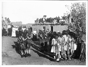 A line of dancing braves in the Hopi Snake Dance Ceremony with onlookers, Oraibi, Arizona, ca.1898