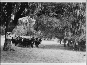 Members of the Sunset Club sitting among the pepper trees, ca.1915