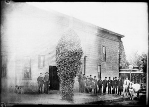 Group of men beside streetcar barns and office, southwest corner of Downey Avenue and Hancock Street, 1890