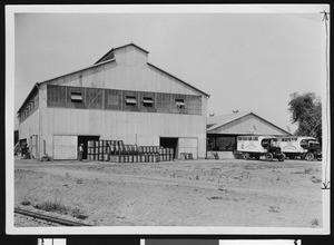 Storage area for the Pacific R & H Chemical Company, showing men standing near central building, El Monte, October 1924