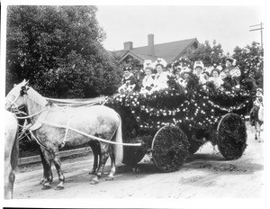 Women seated in a horse-drawn float in the Pasadena Tournament of Roses Parade, ca.1905