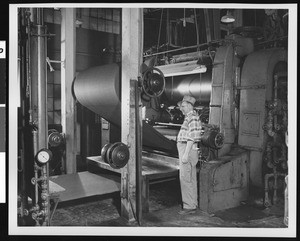 Interior view of an unidentified factory, with a close-up of male worker, ca.1940