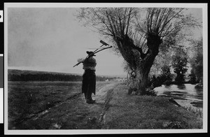 The painting "End of Day" by Adan, depicting a worker making his way down a country path with his tools