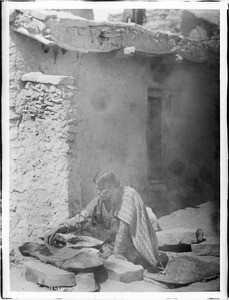 Hopi Indian woman making piki (bread) in the village of Oraibi, ca.1900