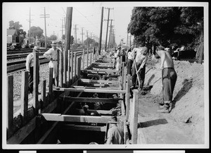 Workers constructing a storm drain next to railroad tracks, ca.1900