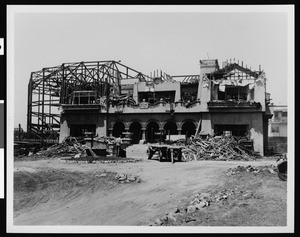 Exterior view of the Paul deLongpre residence during a phase of the house's demolition, 1927