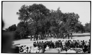 Outdoor play showing a band and a group dressed like Native Americans with one man on the ground, Claremont, ca.1930