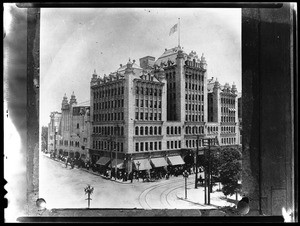 Exterior view of the Philharmonic Auditorium Building prior to its remodeling, showing a crowd gathered on the sidewalk