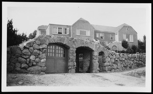 House with a stone wall and garage