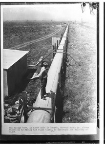 Man standing on a section of the vacuum tube with which Dr. Albert Michelson measured the velocity of light, Irvine Ranch, ca.1931