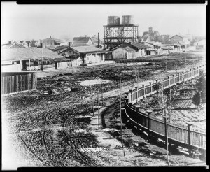 View of San Jose adobes, showing water towers and fence, ca.1900