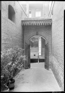 View of the entrance to the Kong Chew Chinese Temple with a drugstore in the background, Los Angeles, November 1933