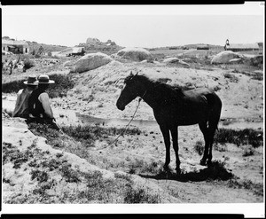 View of the Cahuilla Indian Reservation showing a horse, the church, and the school, 1896