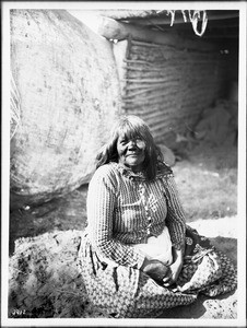 Mojave Indian woman sitting in front of a ramada, ca.1900