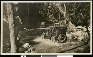 Automobiles fording a stream on a canyon road north of Pasadena, ca.1925