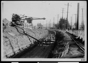 Workers facilitating the pouring of the box section of a storm drain