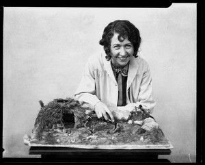 Woman leaning over a display of Native American life at the Pacific Southwest Museum