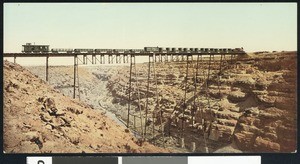 Color view of railway cars on a bridge at Canon Diablo in the Grand Canyon, Arizona, 1900-1940