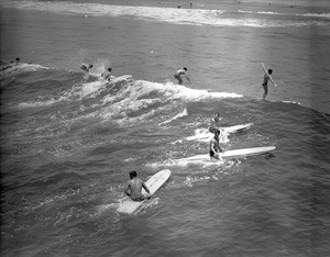 Surfers riding waves at a Los Angeles County Beach, 1950-1960