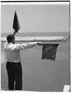 Man operating signal flags at the Marine Exchange in Los Angeles Harbor