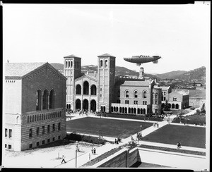 An exterior view of the University of California Los Angeles's Royce Hall with the Goodyear blimp in the background, Westwood, 1930-1950