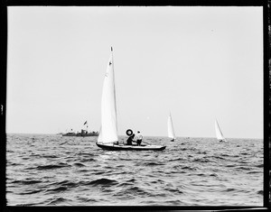Three sailboats on the ocean near a large ship, Long Beach