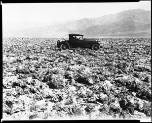 Early-model automobile at the "Devil's Golf Course" area of Death Valley, ca.1928