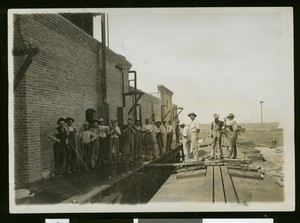 Ice loaders posing with a set of freight cars filled with cantaloupe in El Centro, ca.1910